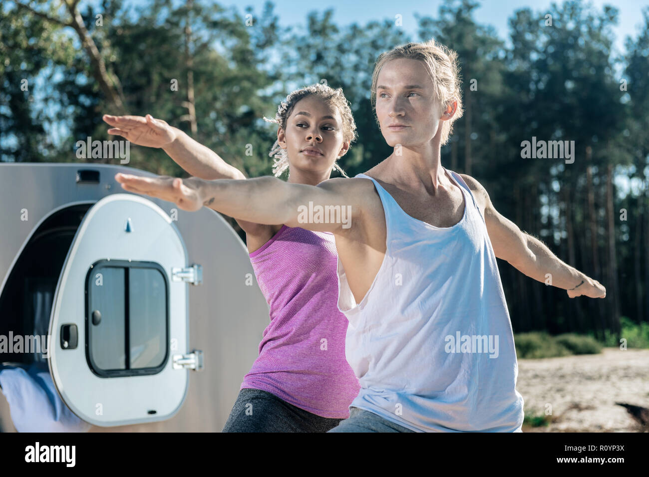 Schönen athletischen Mann Yoga mit seinem schlanken Freundin außerhalb Stockfoto