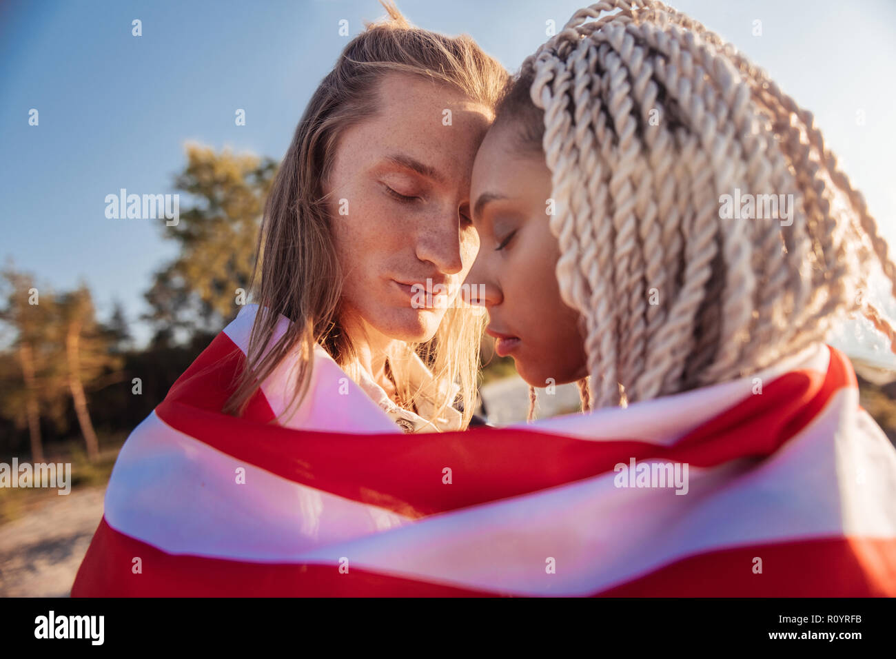 Nahaufnahme der netten gut aussehenden Paare, die zusammen reisen mit National Flagge Stockfoto