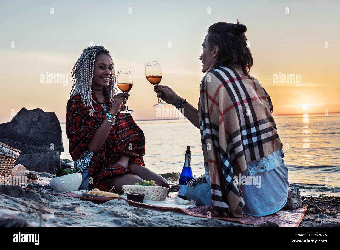 Strahlende Frau trinkt Champagner mit ihrem Mann in Picknick Stockfoto