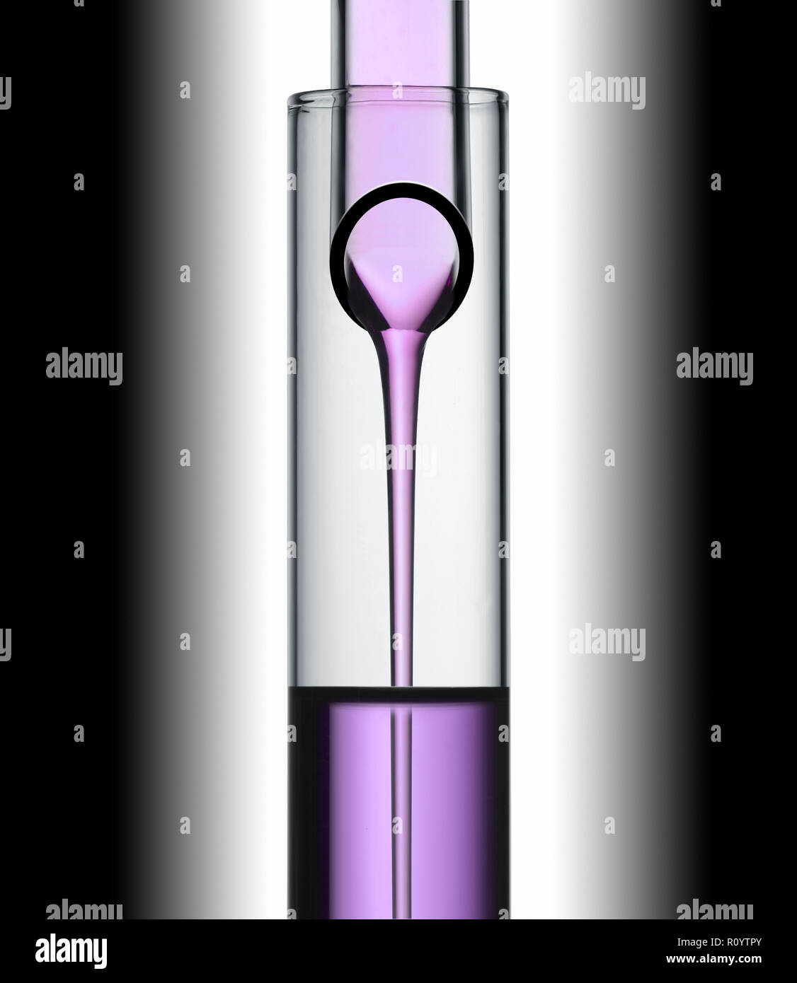 Purple Beauty Behandlung Flüssigkeit gießt aus einem Reagenzglas in einem anderen Studio noch Leben Stockfoto