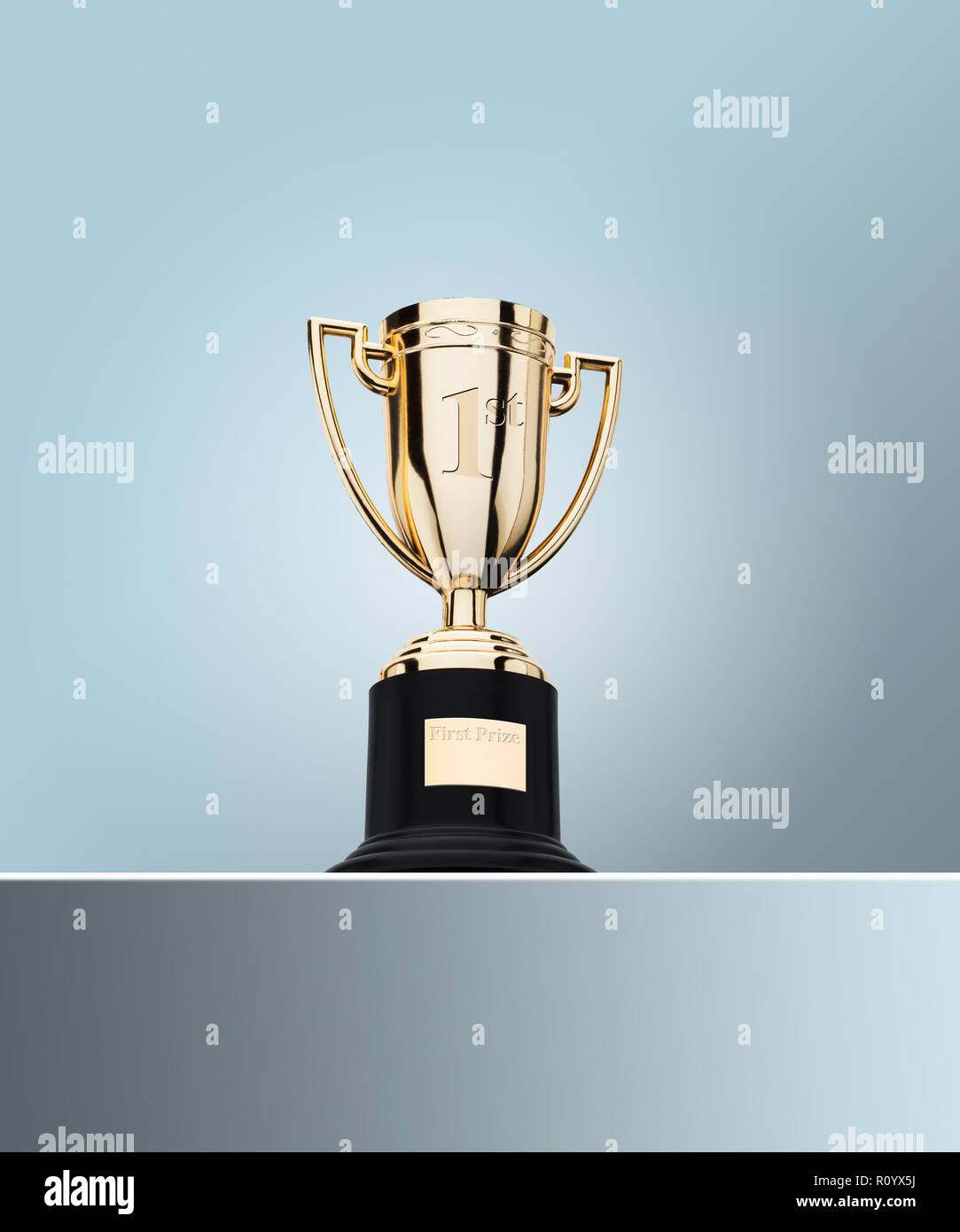 Der erste Preis Gold Cup Trophäe am Tisch gegen grauer Hintergrund Stockfoto