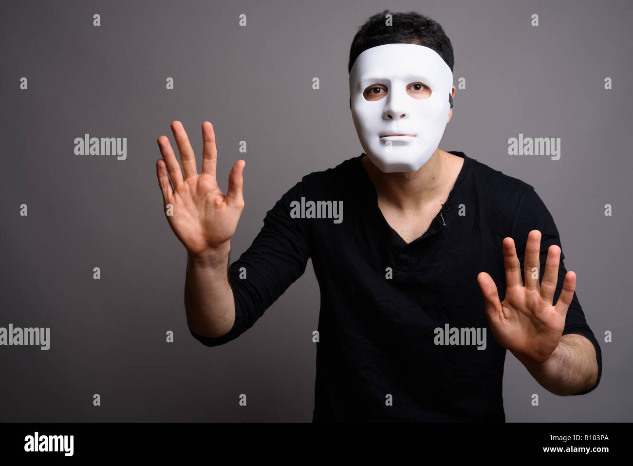 Porträt der jungen gutaussehenden Mann gegen grauer Hintergrund Stockfoto