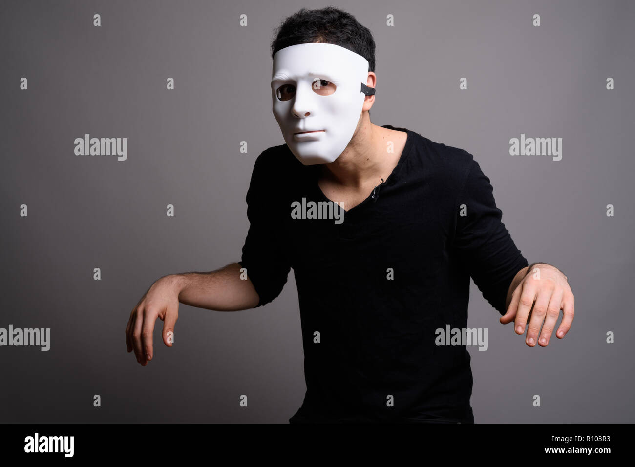 Porträt der jungen gutaussehenden Mann gegen grauer Hintergrund Stockfoto