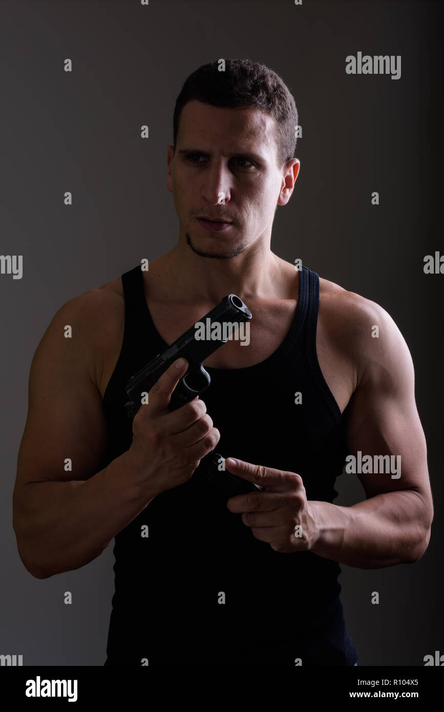 Studio shot der Junge muskulöse Persischen mann Waffe nachladen, während Th Stockfoto