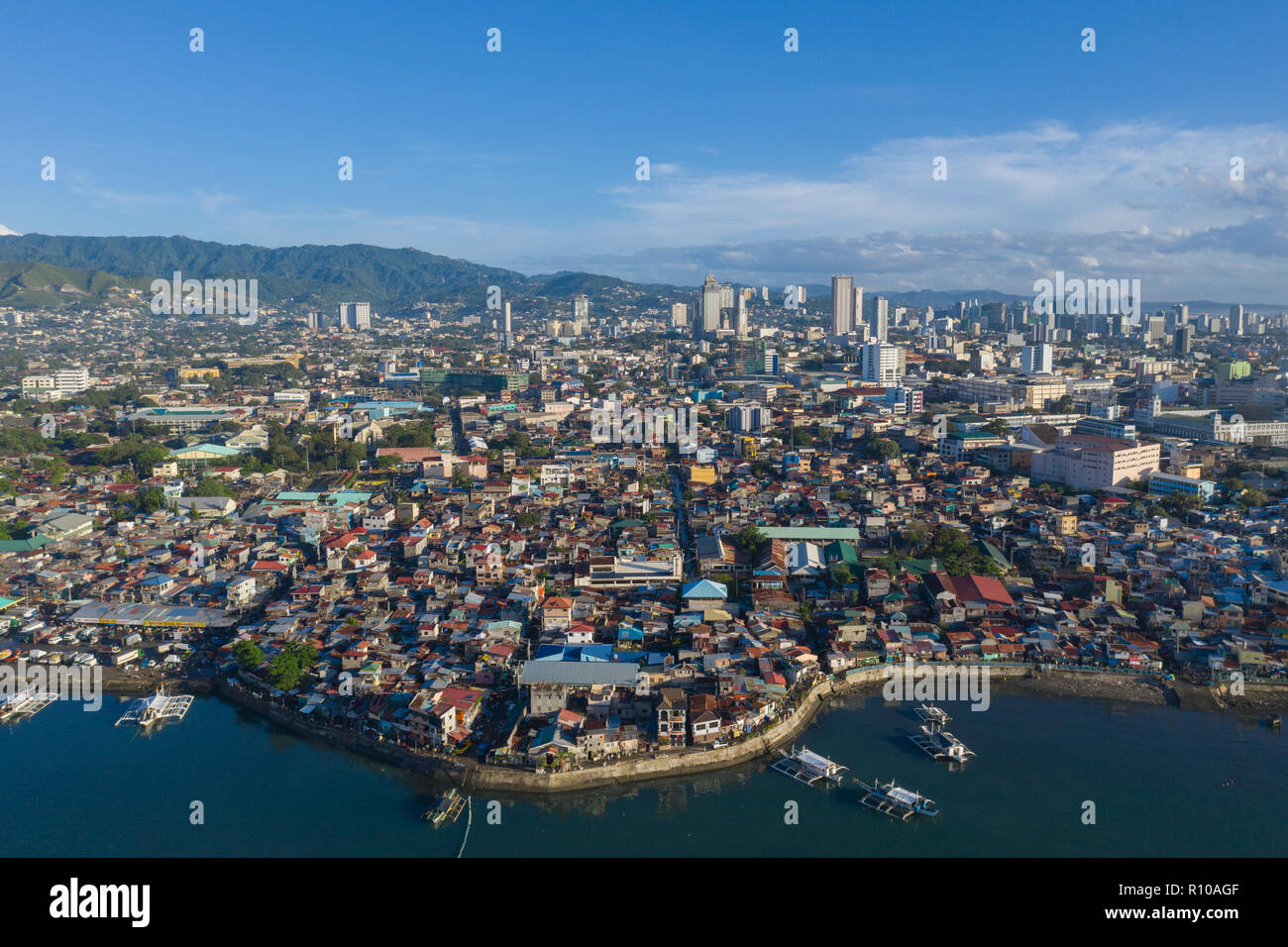 Am frühen Morgen erhöhte Sicht auf Cebu City.Image Features schlecht informell Siedlungen im Vordergrund mit urbaner moderner Stadt Stockfoto
