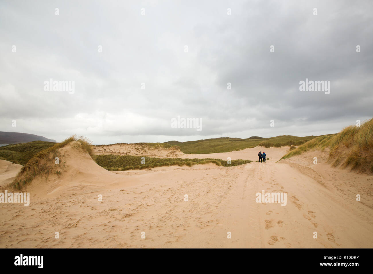 Wanderer zu Fuß durch Sanddünen auf Farraid Kopf, in der Nähe von Durness, Sutherland, Schottland, UK. Stockfoto