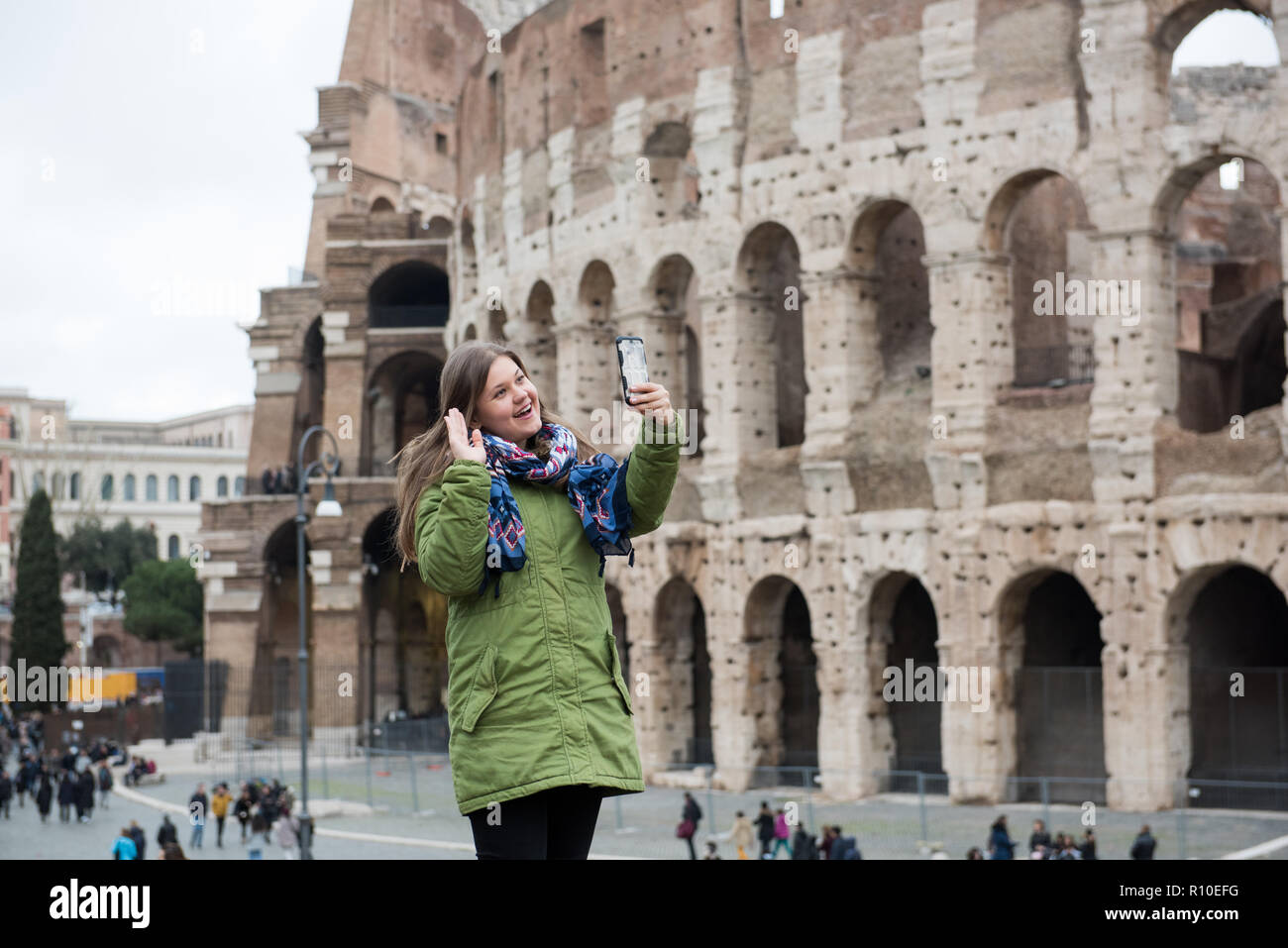 Junge Frau tragen Winter Kleidung vor dem Kolosseum, Rom, Italien, macht selfie mit Smartphone Stockfoto