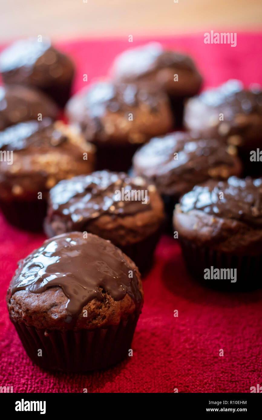 Chocolate Muffins schließen bis auf rotem Tuch. Vertikale erschossen. Stockfoto
