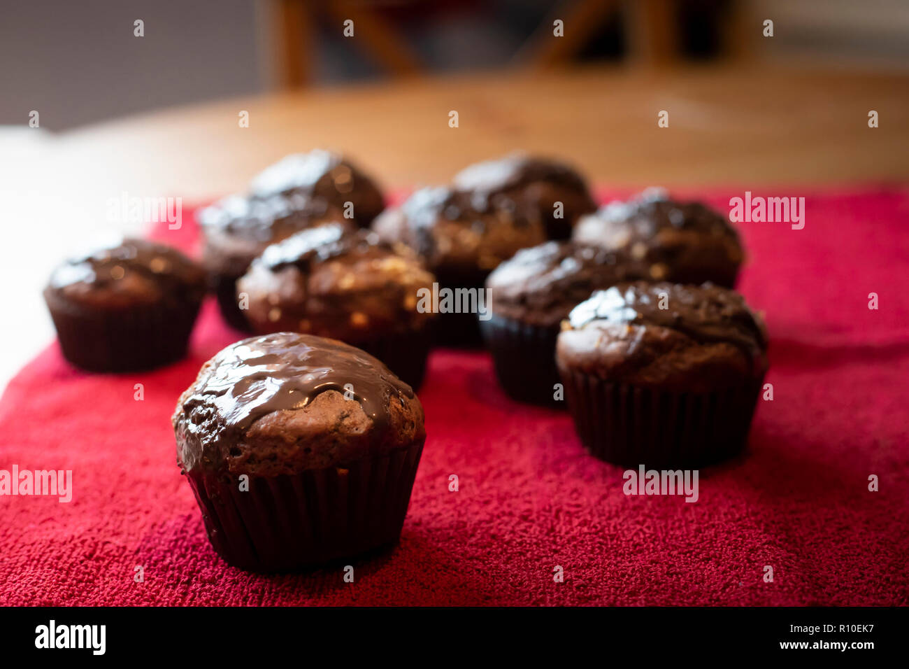 Schokoladen-Muffins aus nächster Nähe auf rotem Tuch. Leckere Lebensmittel Zusammensetzung, hausgemachte Dessert Idee, selektive Fokus. Stockfoto