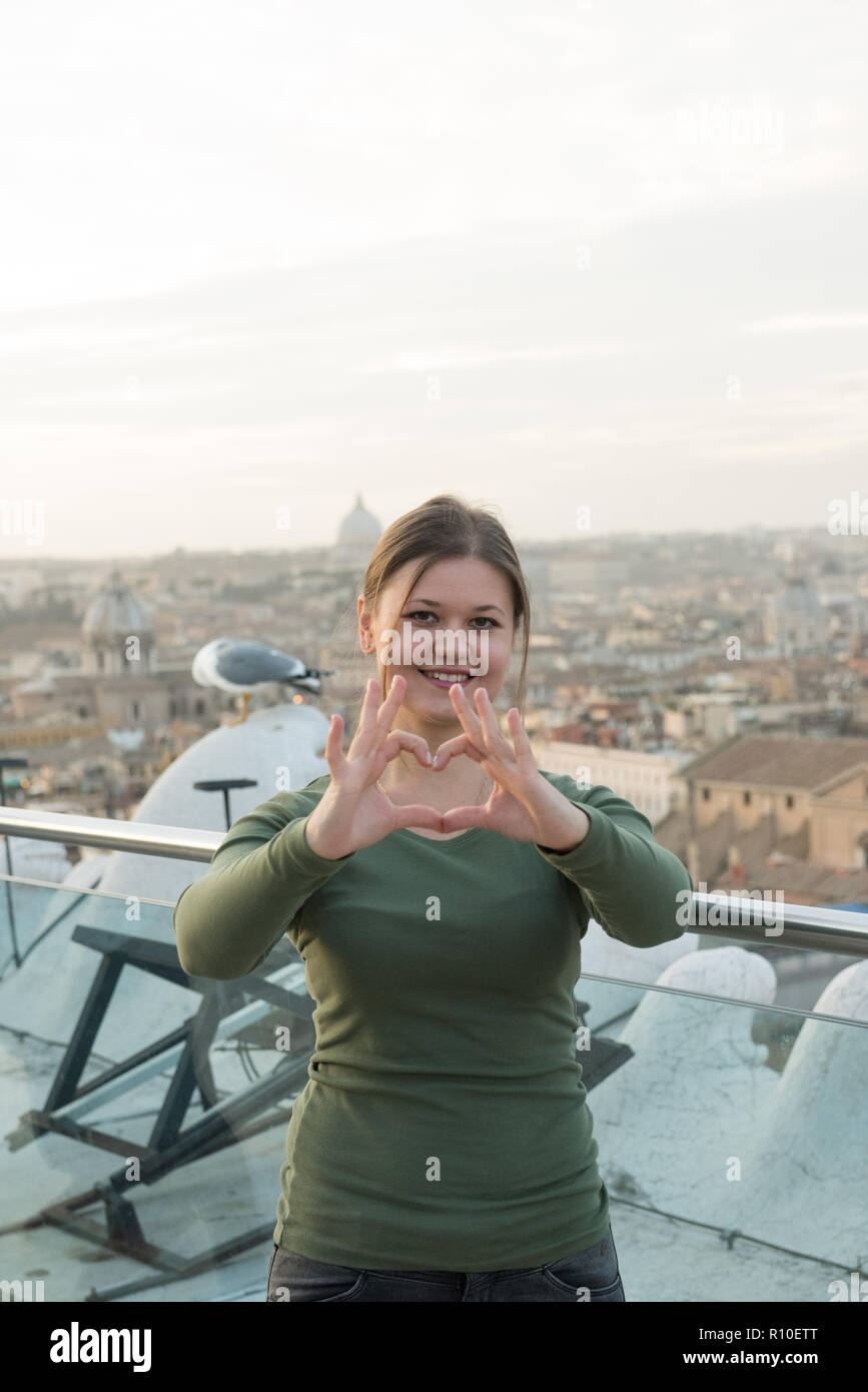 Junge Frau trägt grün Pullover auf dem Dach vor der Vatikan, Rom, Italien, Macht gehört Zeichen Stockfoto