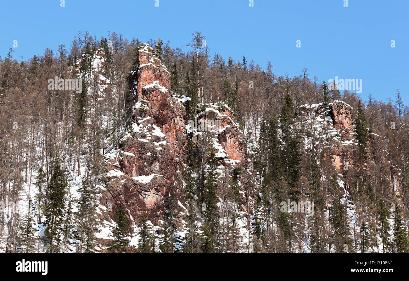 Rötlich verwitterten Felsen im südlichen Jakutien, Russland, im Winter Stockfoto