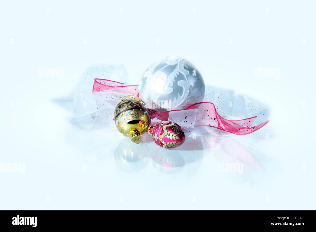 Drei hübsche Weihnachtsdekorationen und Bänder, weißer Hintergrund Stockfoto