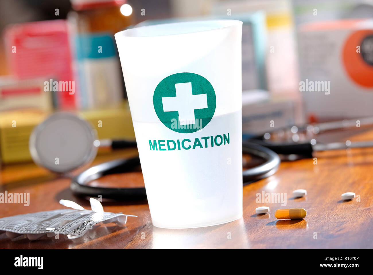 Kunststoff Medikation Tumbler auf Doctor's Table Top Stockfoto