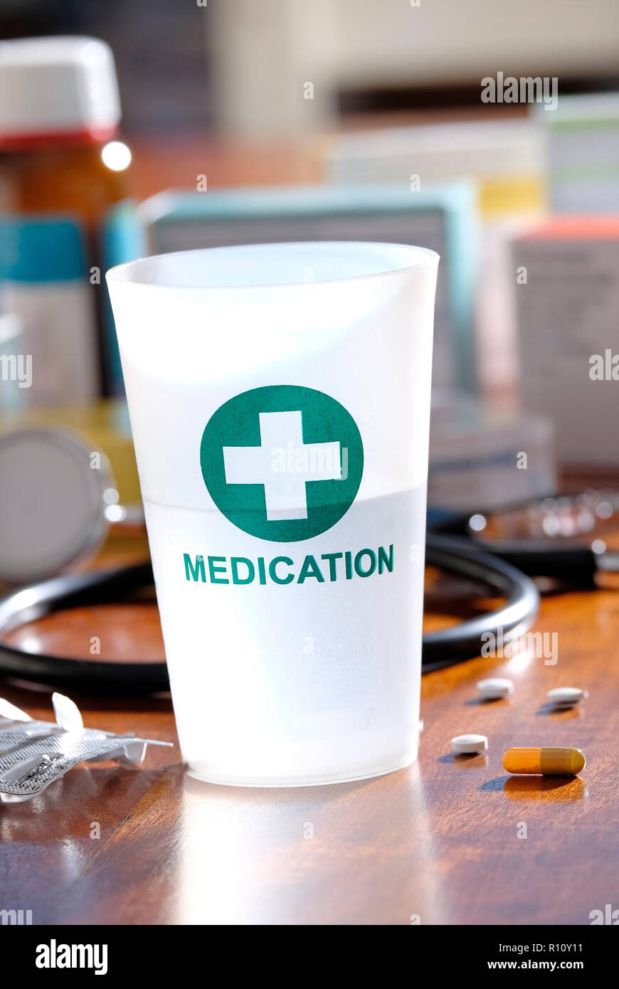 Kunststoff Medikation Tumbler auf Doctor's Table Top Stockfoto