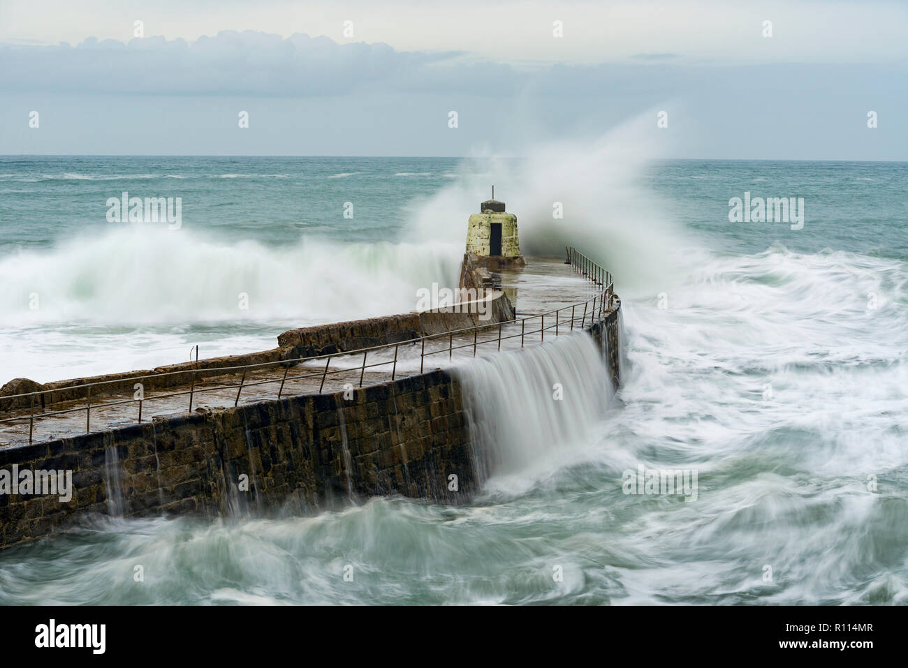 Portreath Monkey Hütte mit einer langen Belichtungszeit, die durch schwere See zerschlagen wird. Stockfoto