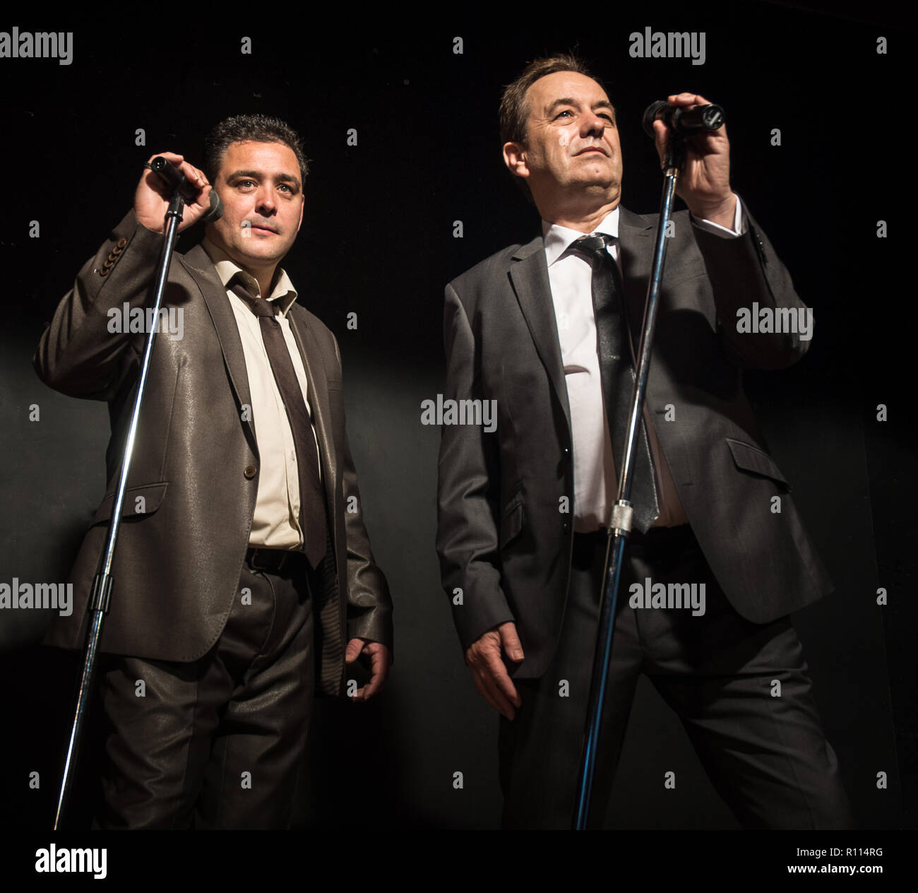 Zwei männliche Swing Jazz Sänger unter den Scheinwerfer mit Mikrofonen auf der Bühne. Stockfoto