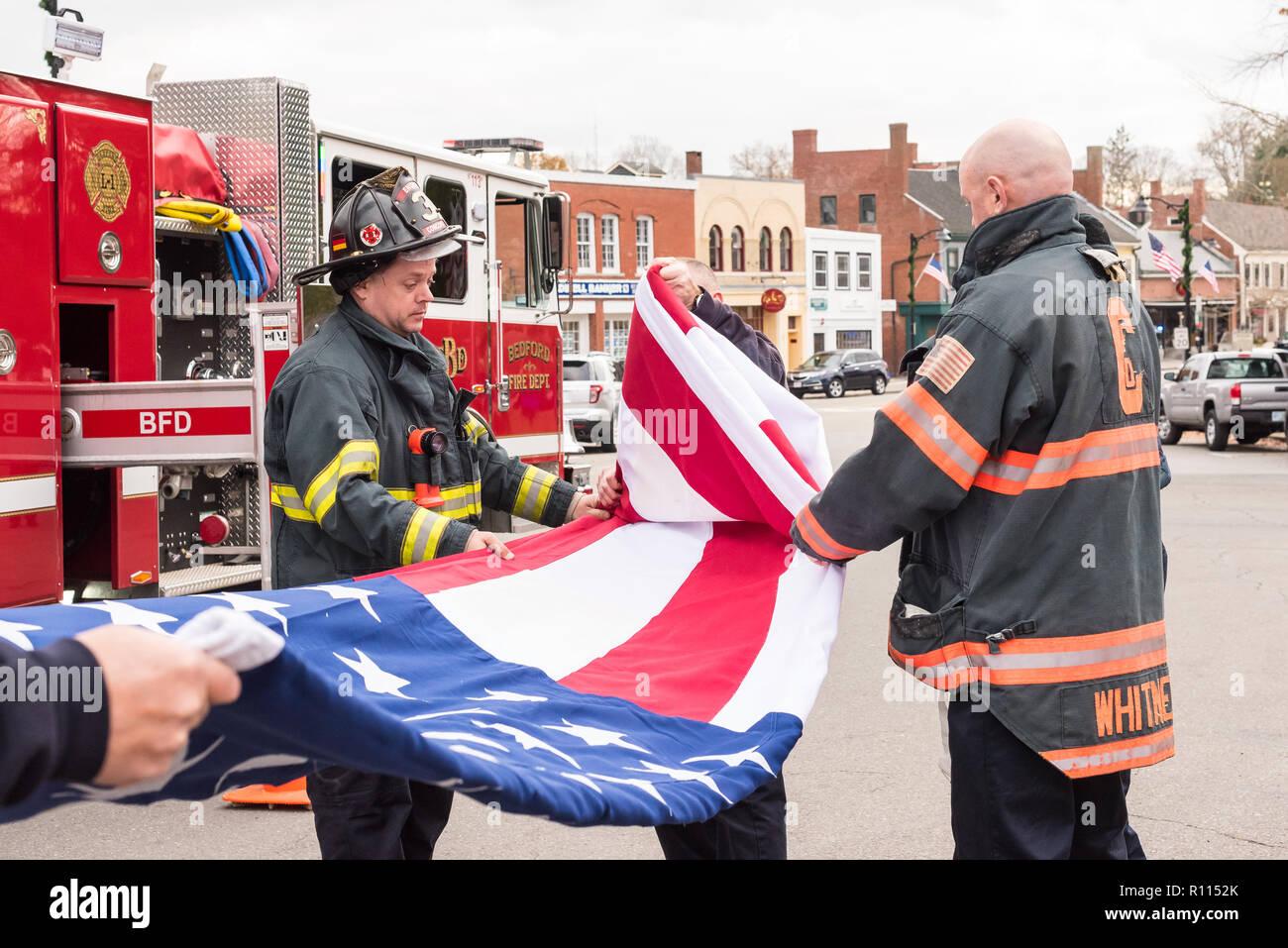 Feuerwehrleute aus Bedford und Concord Feuerwehren Falten die Flagge nach dem Trauerzug für die Ehrenmedaille Empfänger Thomas J. Hudner. Stockfoto