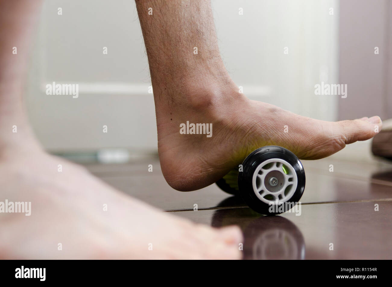 Plantar Fasciitis. Sufferer mit einem Fuß Walze zu Hause zur Behandlung. Stockfoto