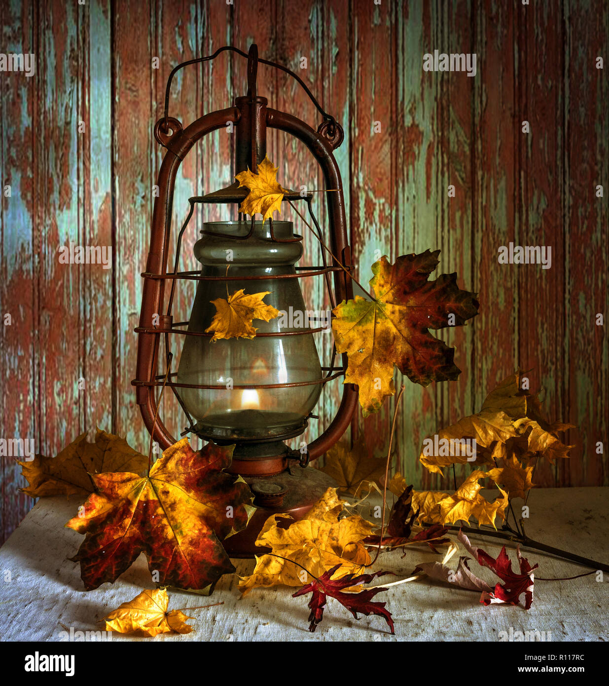 Stillleben mit Blätter im Herbst und eine Petroleumlampe. Vintage Stockfoto