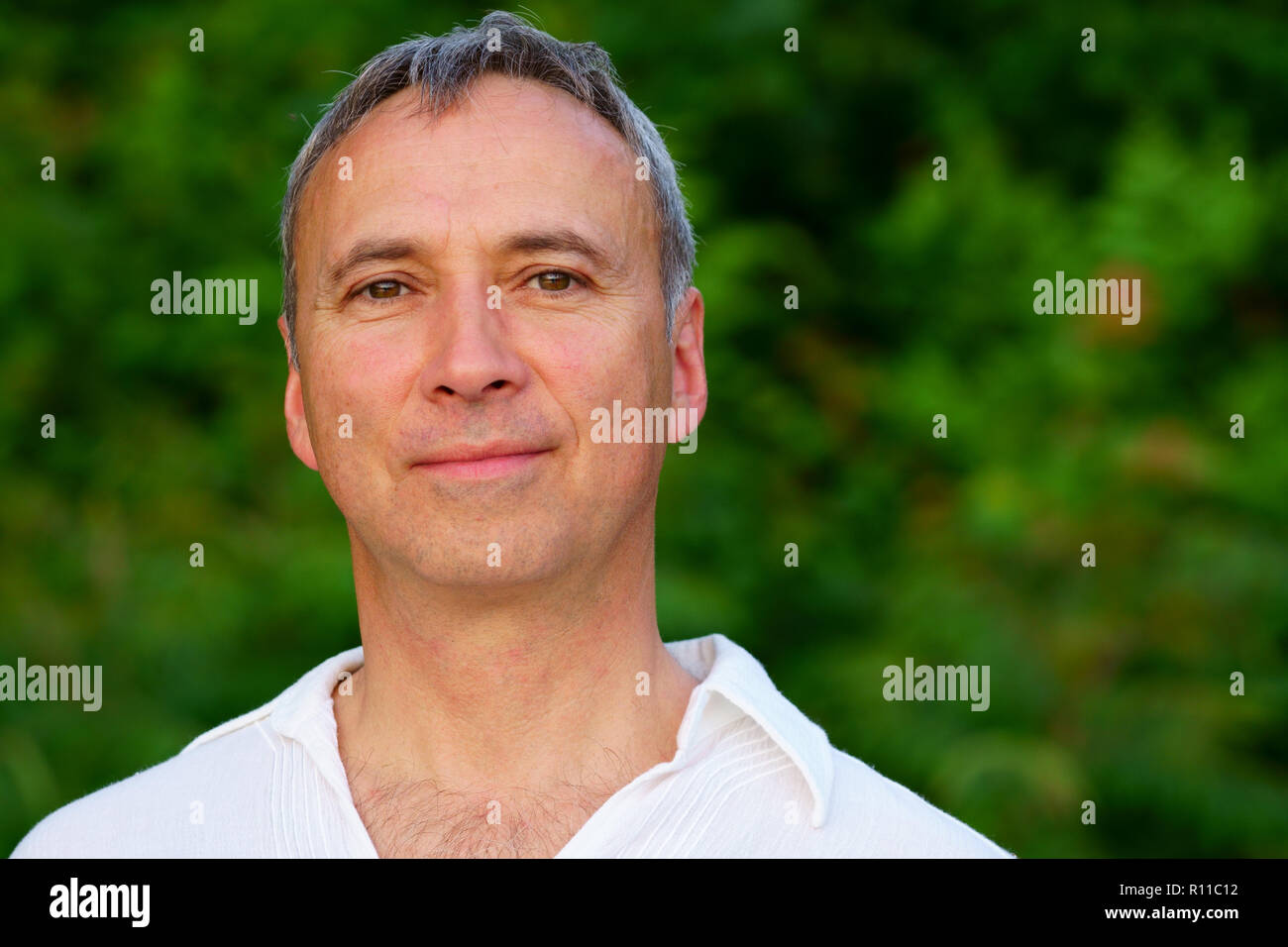 Porträt eines stolzen gesunden kaukasischen Mann, 50, trägt einen weißen Anzug, nach einer Meditation Sitzung von dem Fluss am Sonnenuntergang. Stockfoto