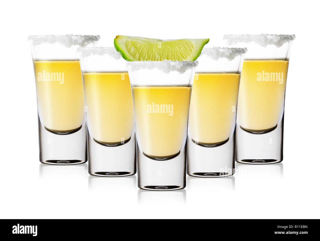 Fünf Gläser golden Tequila mit Salz und Limette Stockfoto