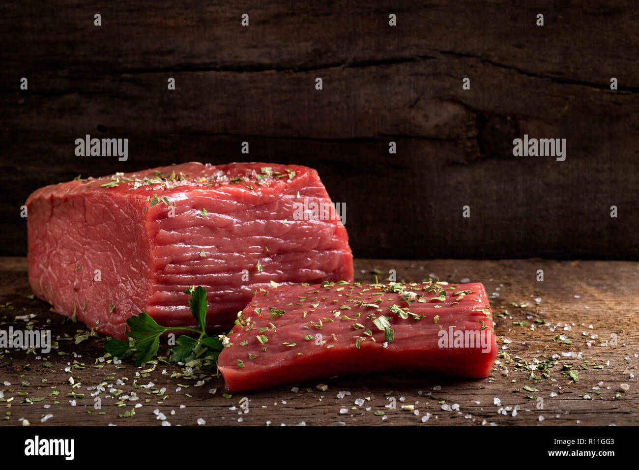 Rohes Rindfleisch Fleisch mit Kräutern auf Holz rustikale Hintergrund Stockfoto
