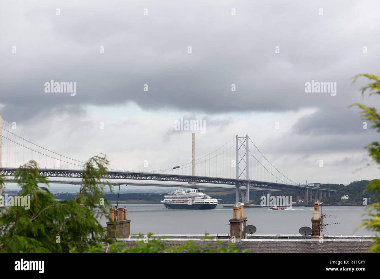 Ein großes Schiff läuft unter die Forth Road Bridge, South Queensferry, Schottland, UK Stockfoto