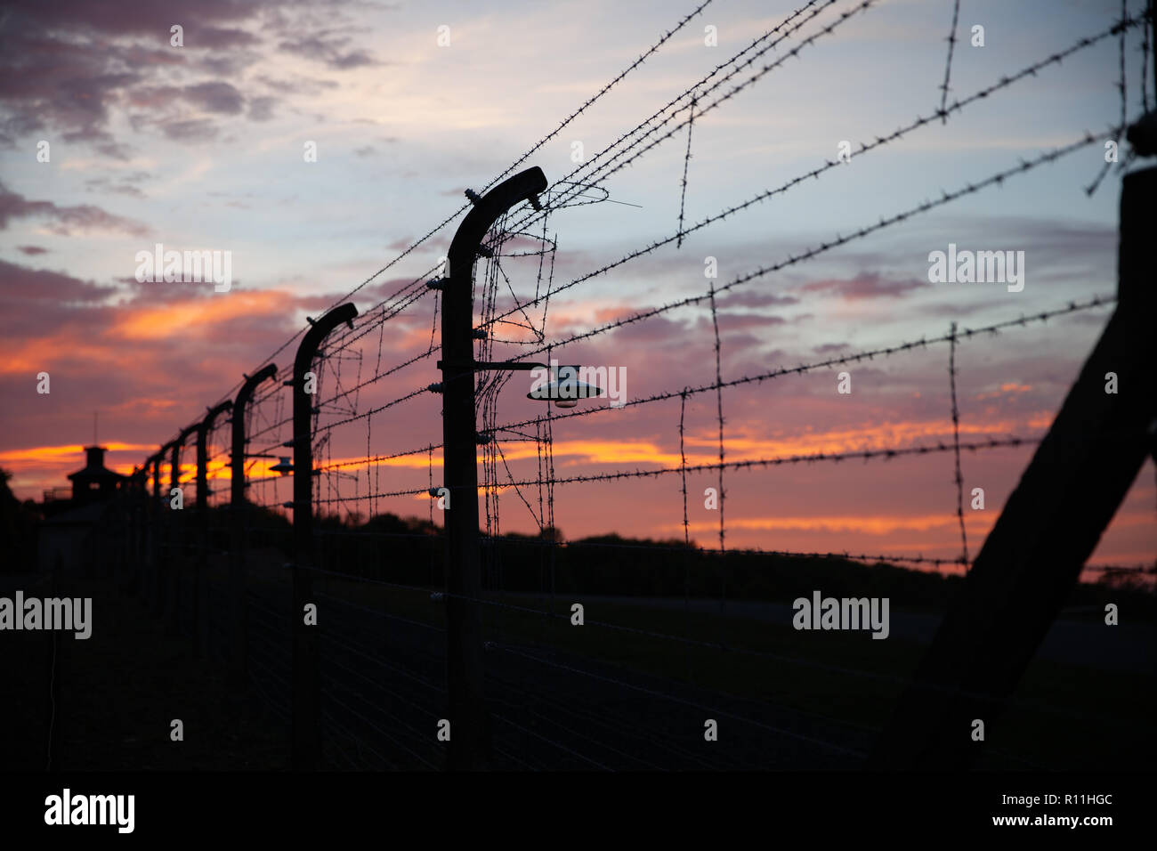Detailansicht der antiken Stacheldraht zaun aus dem Konzentrationslager Buchenwald auf dunklen Sonnenuntergang Himmel Hintergrund Weimar Deutschland Stockfoto