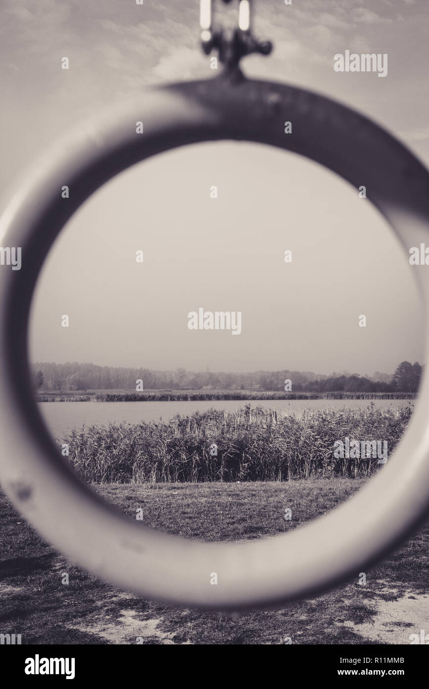 Schwarze und weiße Blick durch Kreis auf dem See und Schilf Stockfoto