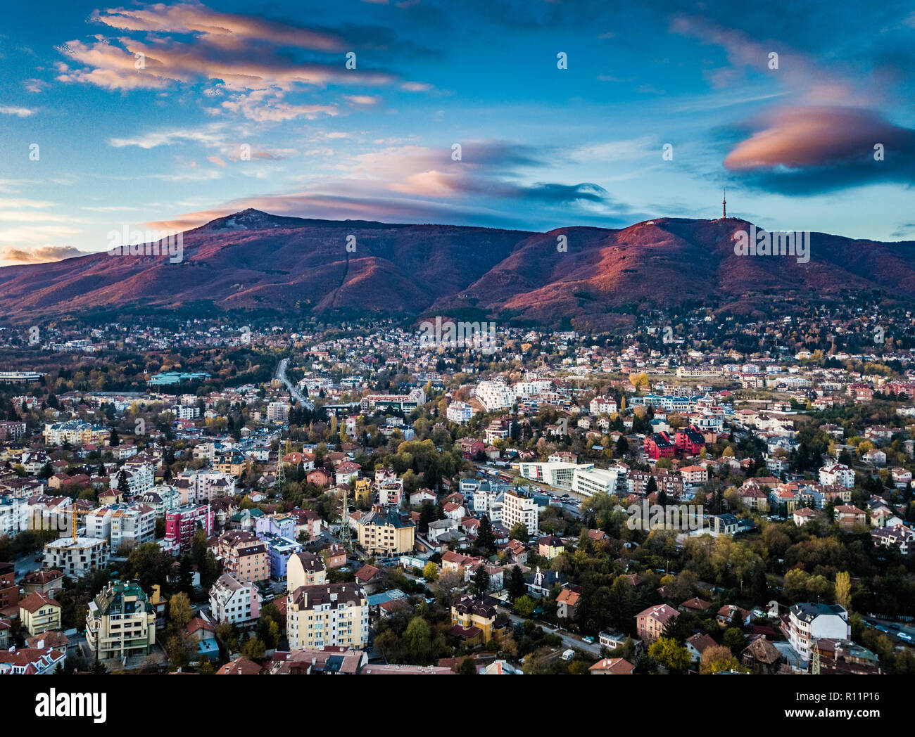 Schöne drone Schuß über die Stadt Sofia bei Sonnenaufgang - erstaunlich lebendiges Bild mit bunten Himmel, Bergkulisse und typischen Stadtbild Stockfoto