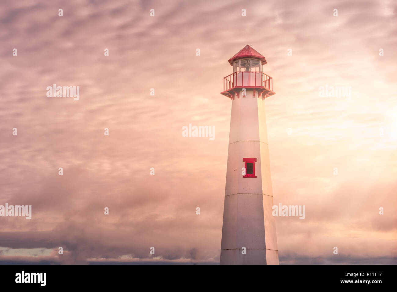 Golden Hour mit Sonnenstrahlen Schuß von Wawatam Leuchtturm am Hafen von St. Ignace, Michigan in den Straßen von Mackinac Stockfoto