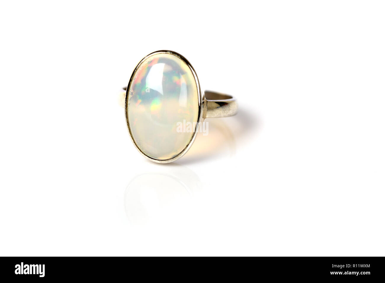 Opal Ring in Silber irisierend auf weißem Hintergrund Stockfoto