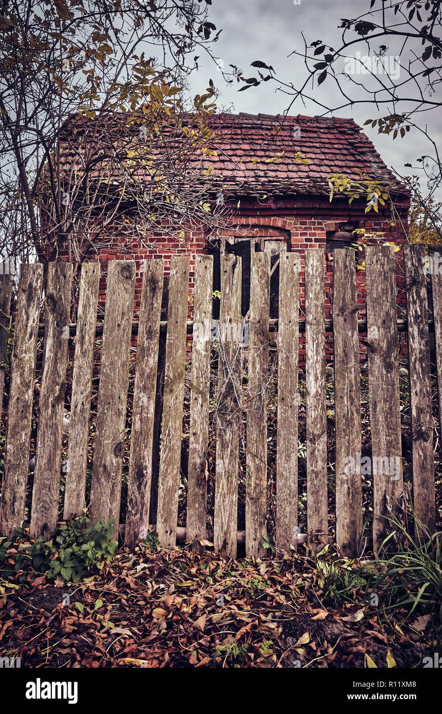 Alte holzzaun vor eine gespenstische, verlassenes Haus, Farbe Tonen angewendet. Stockfoto