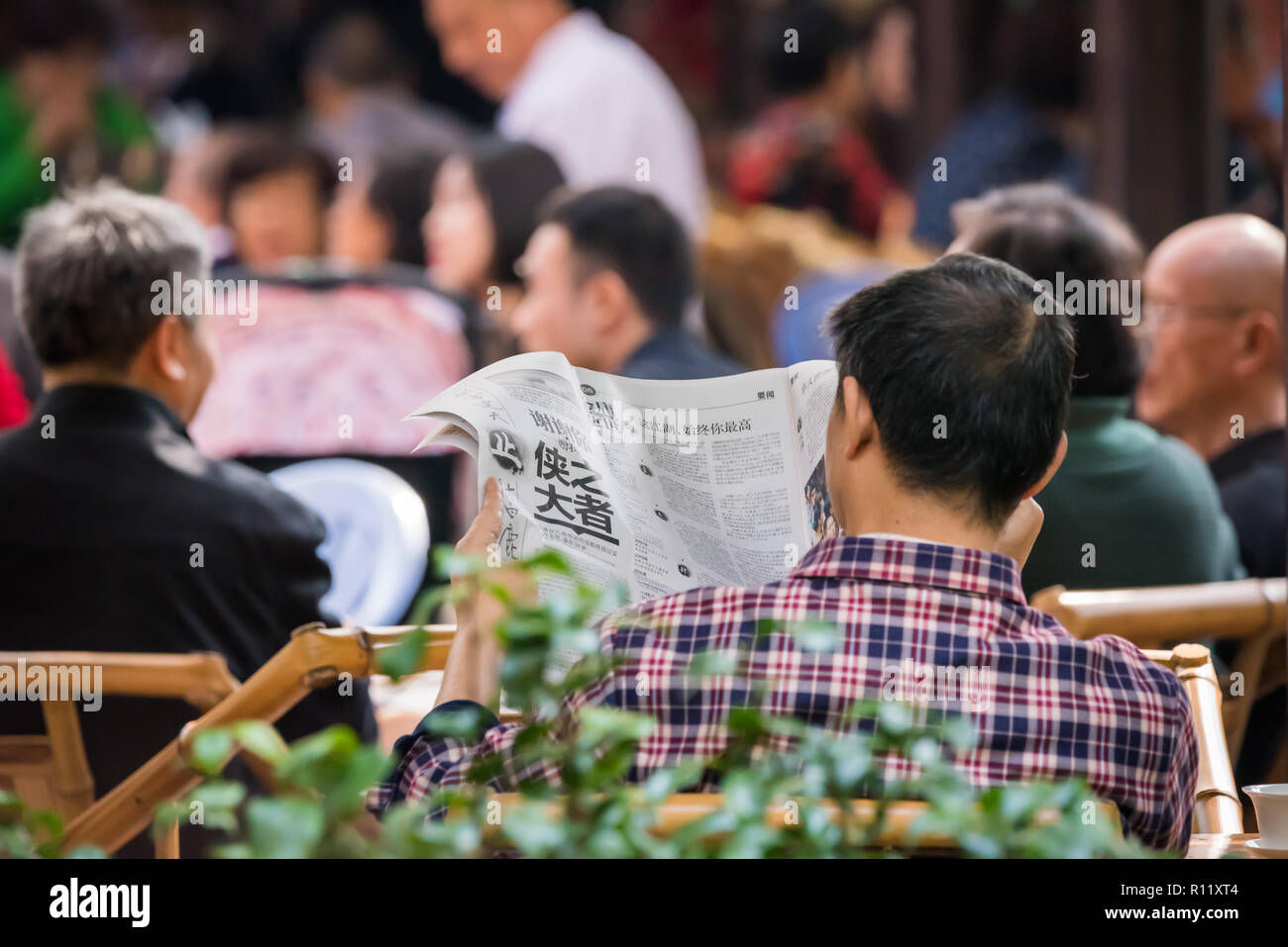 Chengdu, Provinz Sichuan, China - 31.Oktober 2018: Der Mann, der seine Zeitung lesen am Morgen in den Park alte Teestube Stockfoto