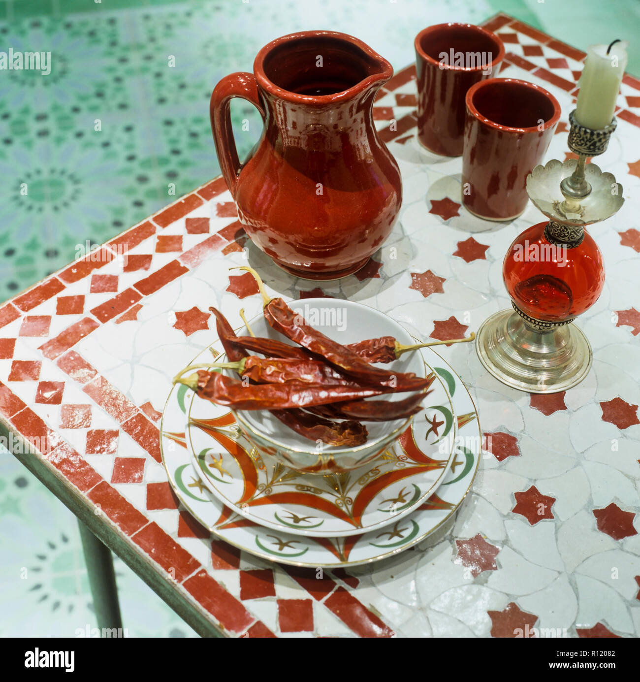 Getrocknete Chilis und ethnischen Stil Kerze auf dem Tisch Stockfoto
