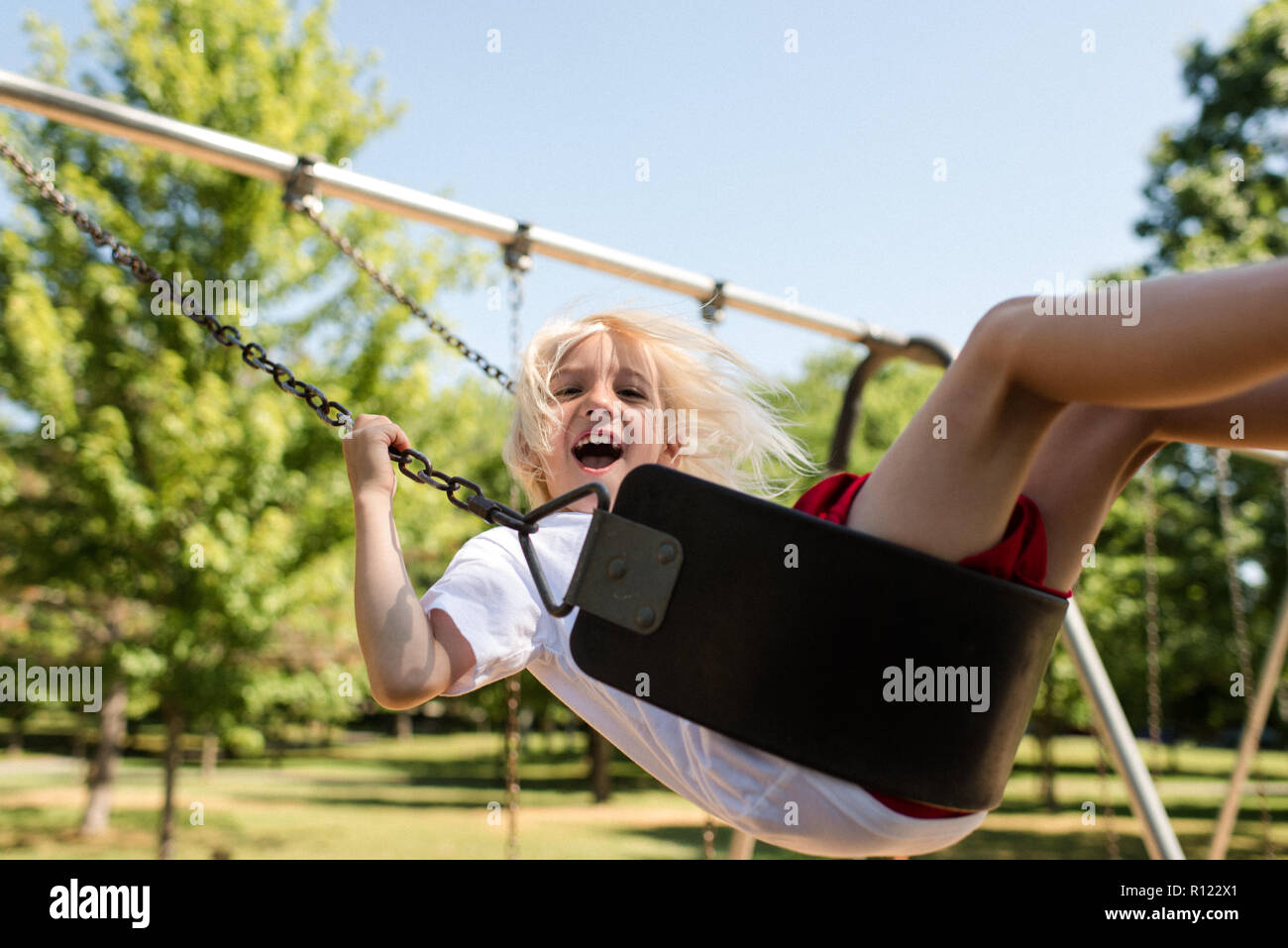Junge auf Schaukel im park Stockfoto
