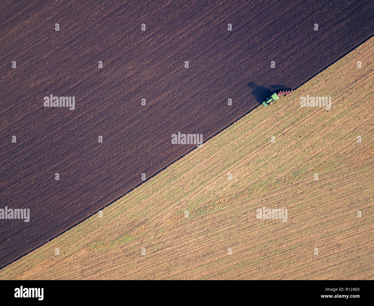Luftbild von einem Traktor pflügen ein Feld in einer Landschaft, Land Business Konzept. Pflügen im Herbst, Drone erschossen. Stockfoto