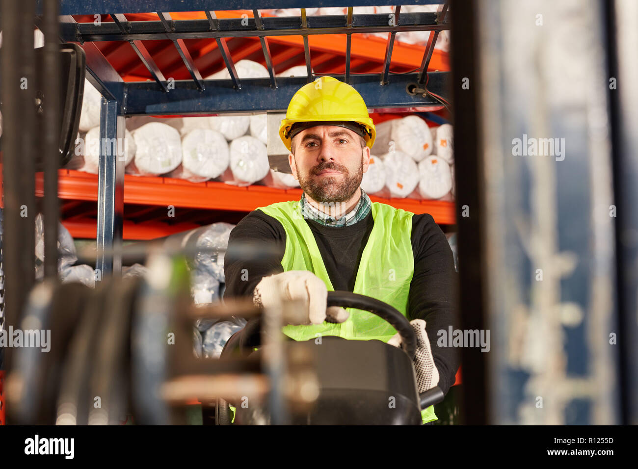 Arbeitnehmer als Gabelstapler Fahrer auf dem Gabelstapler im Lager Stockfoto