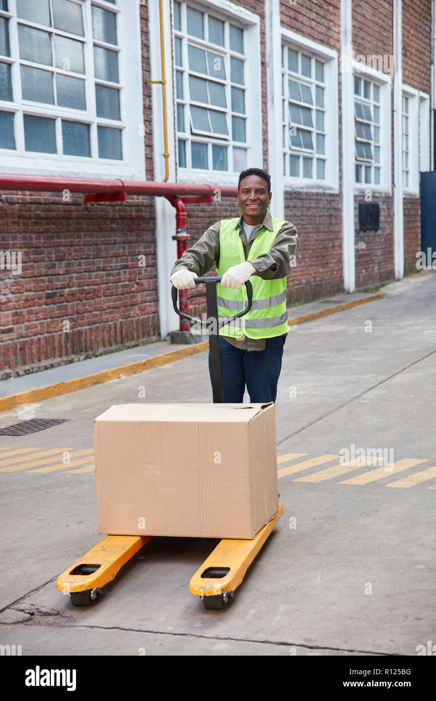 Afrikanische Logistik Mitarbeiter trägt ein Paket auf der Palette Lkw Stockfoto