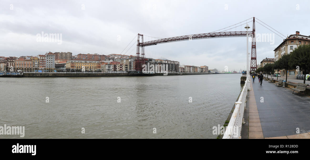 Einen Anblick der Portugalete vom Fluss Promenade, mit der Antenne Vizcaya Brücke (Puente de Vizcaya) am Fluss Nervion in einem trüben Wintertag, Spanien Stockfoto