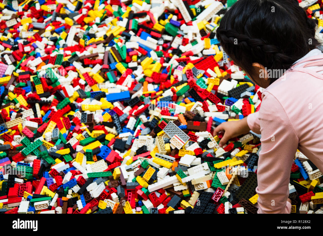 Kleine Mädchen spielen mit vielen Kunststoff Bausteine Teile. Pädagogisches Spielzeug für Kinder Stockfoto