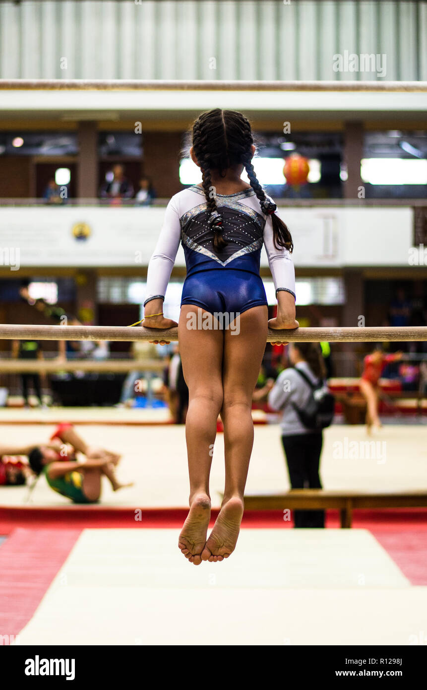 Sportliche Mädchen gymnast Übungen an der Bar in der Meisterschaft Stockfoto