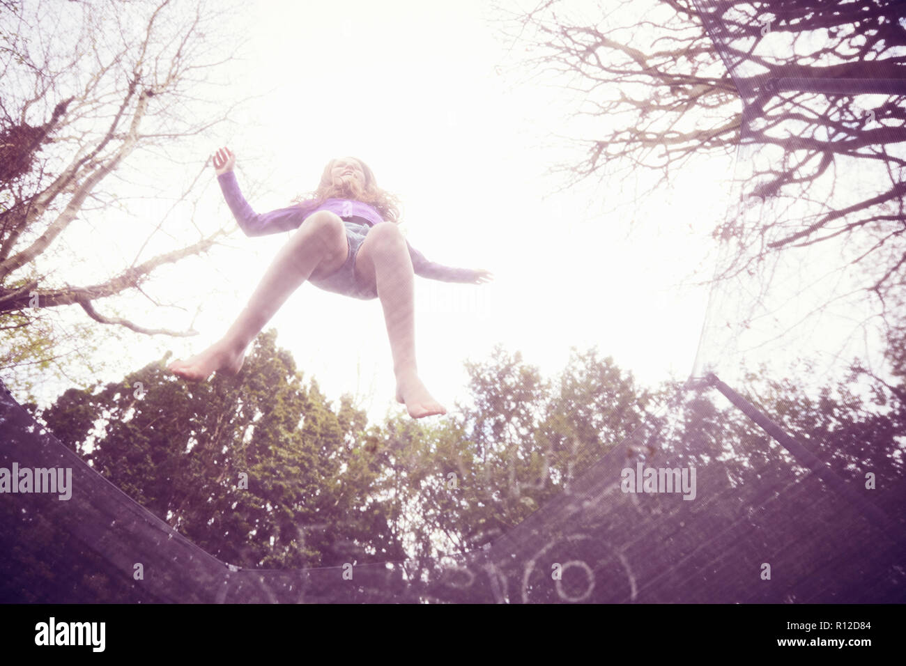 Mädchen springen auf Trampolin, Low Angle View Stockfoto