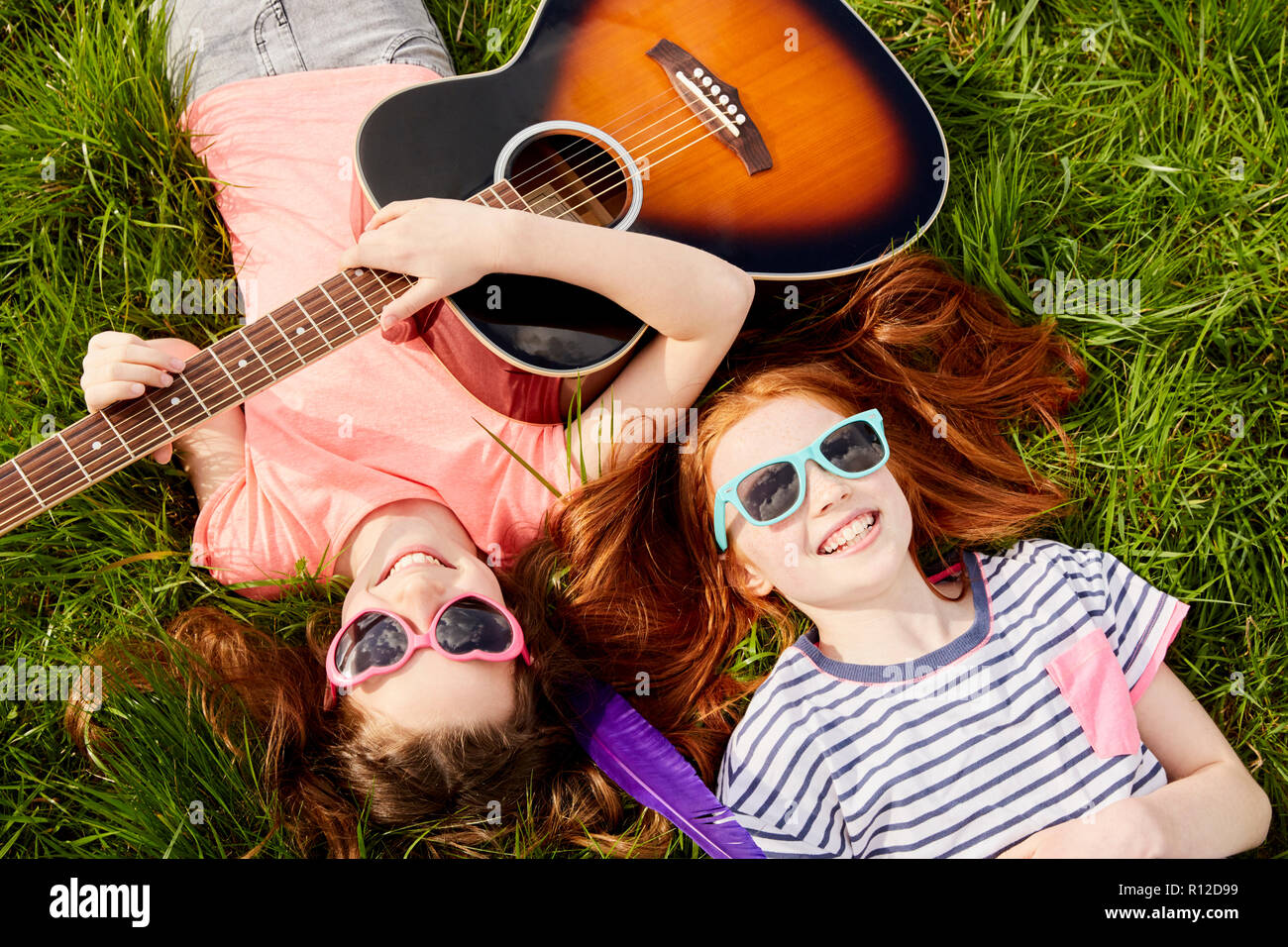 Mädchen mit Gitarre auf Gras Stockfoto
