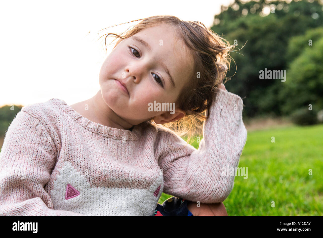 Kind sitzen auf Gras im Park Stockfoto
