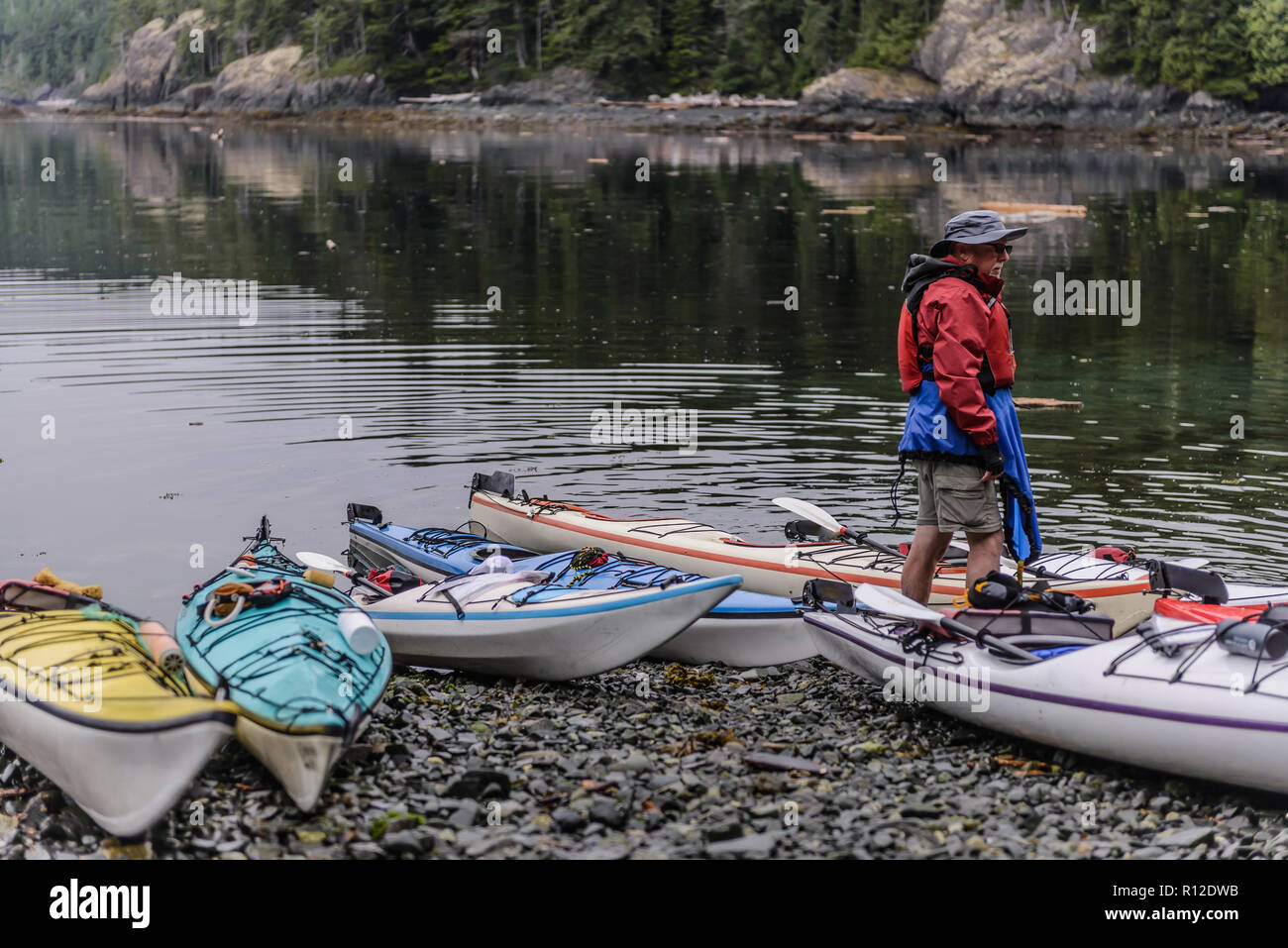 Mann mit Kajaks auf See, Johnstone Strait, Telegraph Cove, Kanada Stockfoto