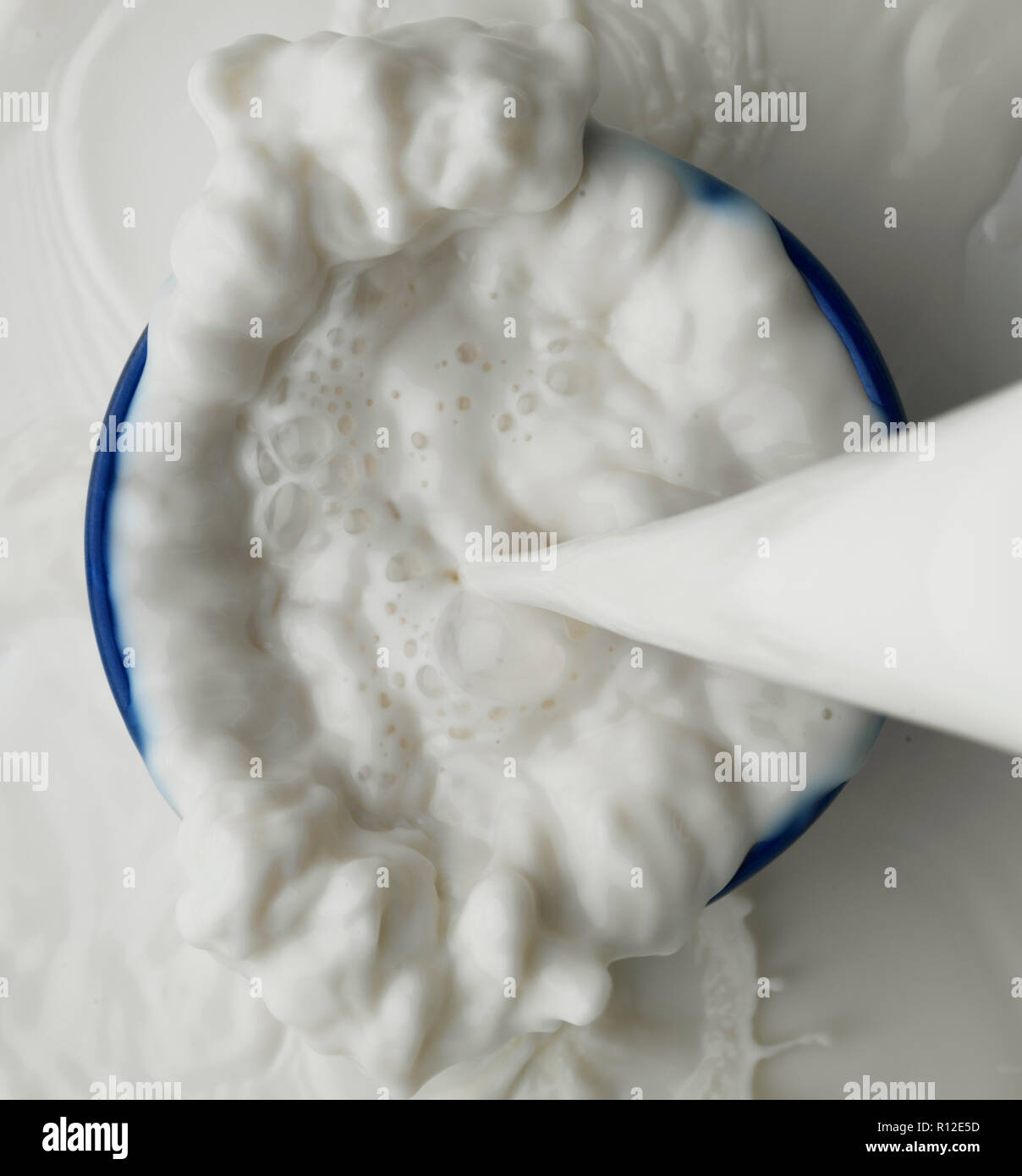Milch in Schüssel geschüttet wurde Stockfoto