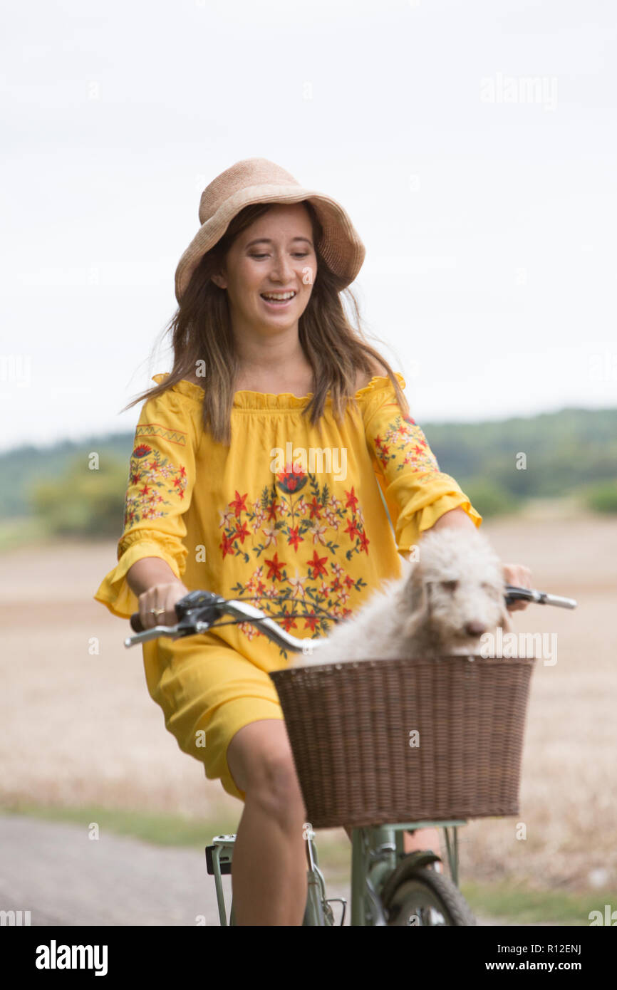 Frau Radfahren mit Hund in der Landschaft Stockfoto