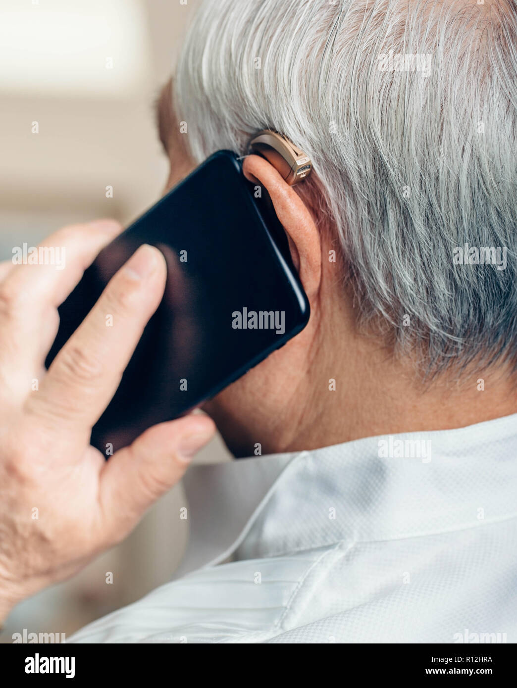 Ältere Menschen mit Hörgeräten Gespräch per Telefon Stockfoto