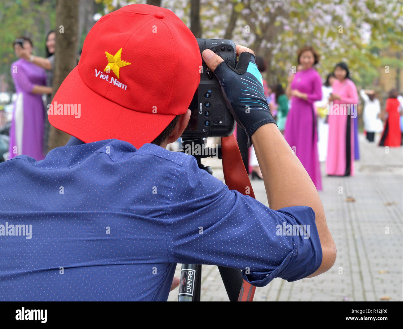 Professionelle vietnamesische Fotografin nimmt Portrait Fotos, die mit einer DSLR-Kamera Canon EOS 1DX in der Nähe von Hanoi die Bac Sohn Denkmal. Stockfoto